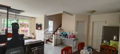 Spacious living area with modern decor and natural light, featuring a staircase and open layout.