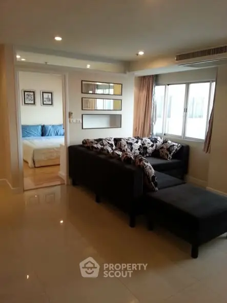 Spacious living room with modern decor and cozy bedroom view
