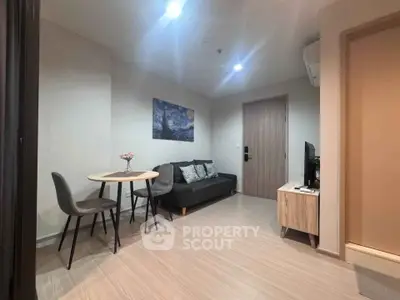 Modern living room with cozy sofa, stylish decor, and compact dining area in a contemporary apartment.