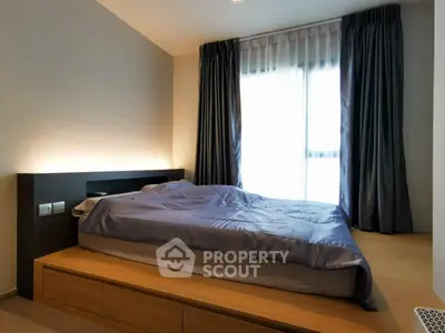 Modern bedroom with sleek design and natural light through large windows.