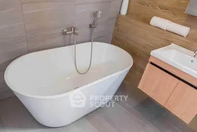 Modern bathroom with sleek freestanding bathtub and stylish wooden vanity.