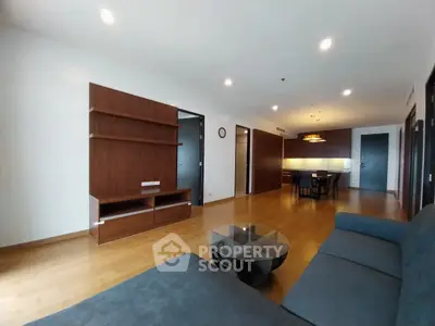 Spacious modern living room with wooden flooring and open layout in luxury apartment.