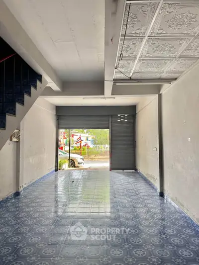 Spacious open-plan interior with patterned blue tile flooring and decorative ceiling panels.