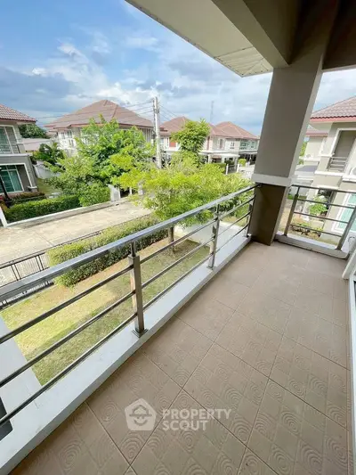 Spacious balcony with scenic neighborhood view in modern residential area.