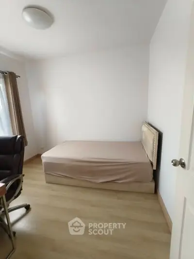 Cozy bedroom with natural light and minimalist decor, perfect for relaxation and comfort.