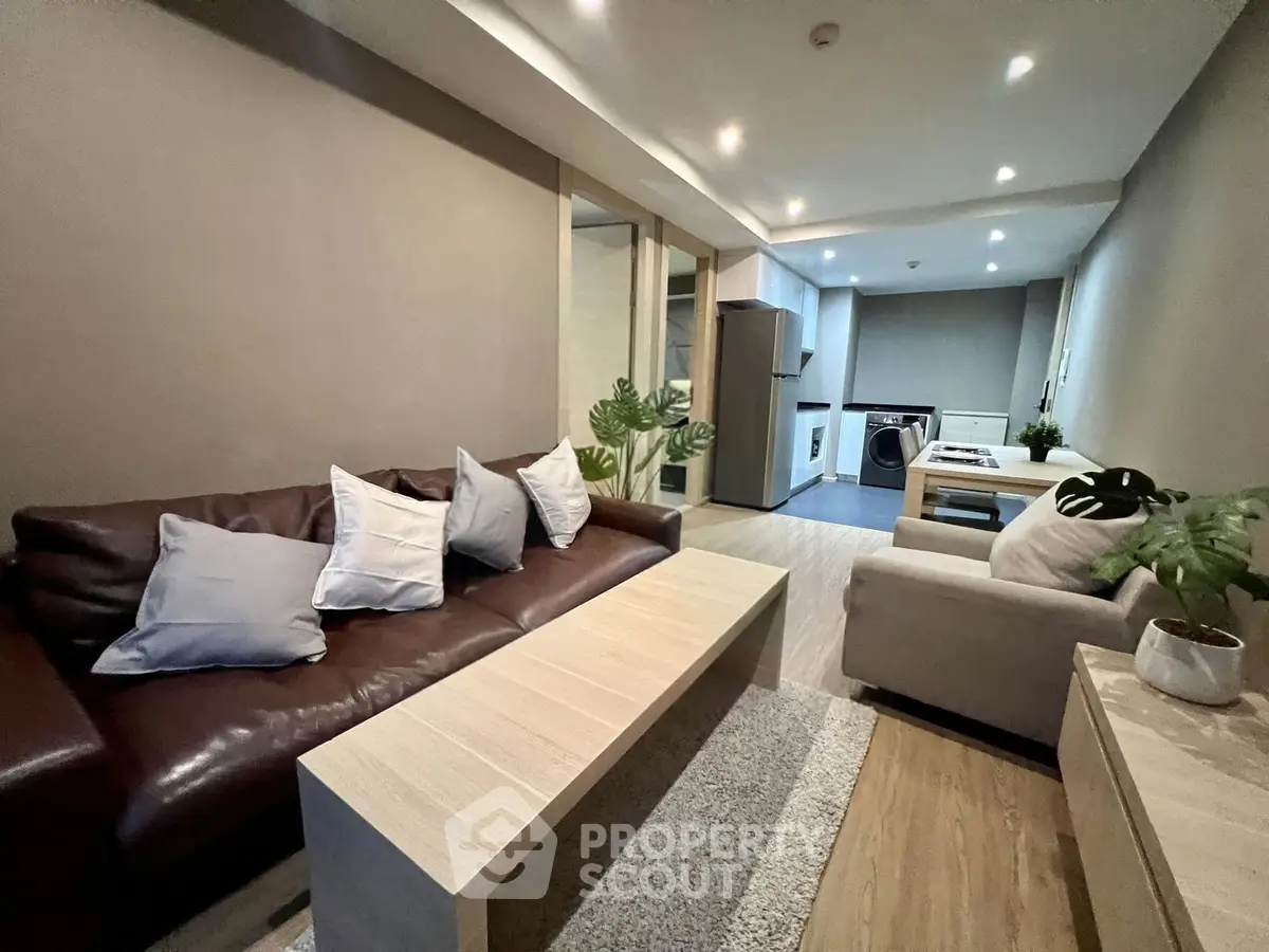 Modern living room with stylish furniture and open kitchen layout, perfect for cozy urban living.