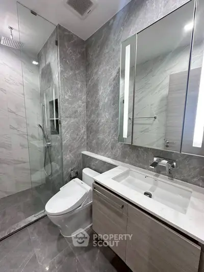 Modern bathroom with sleek design, featuring a glass shower and elegant vanity.