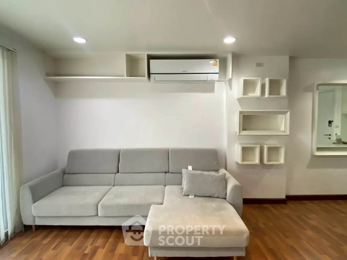 Modern living room with sleek gray sofa and stylish wall shelves, perfect for contemporary living.