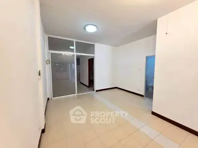 Spacious empty room with tiled floor and bright lighting, ideal for customization.