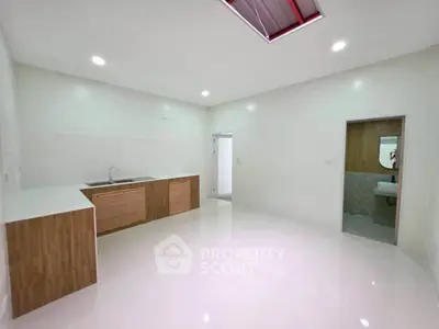 Spacious modern kitchen with sleek cabinetry and bright lighting, perfect for culinary enthusiasts.