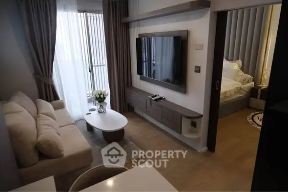 Modern living room with sleek TV setup and cozy bedroom view