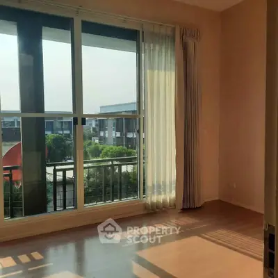 Bright empty room with large windows and balcony view in modern apartment.