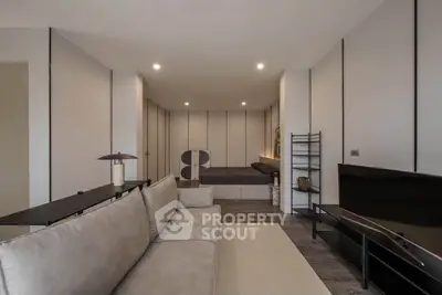 Modern living room with sleek design and neutral tones, featuring a comfortable sofa and stylish decor.