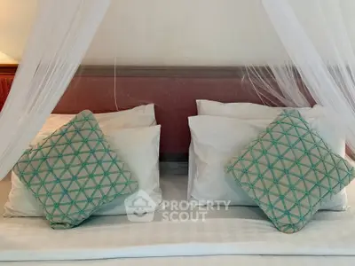 Luxurious bedroom with elegant pillows and canopy, perfect for relaxation and comfort.