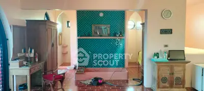 Charming eclectic interior with vibrant teal accent wall and rustic wooden furniture.