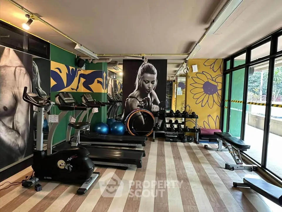 Modern gym with exercise equipment and motivational wall art in a vibrant setting.