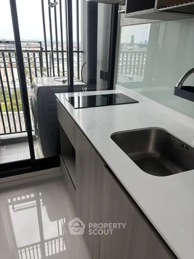 Modern kitchen with sleek design and city view from balcony