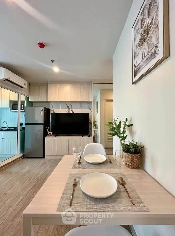 Modern living room with dining area and kitchen, featuring stylish decor and open layout.