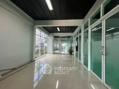 Spacious commercial space with glass partitions and modern lighting