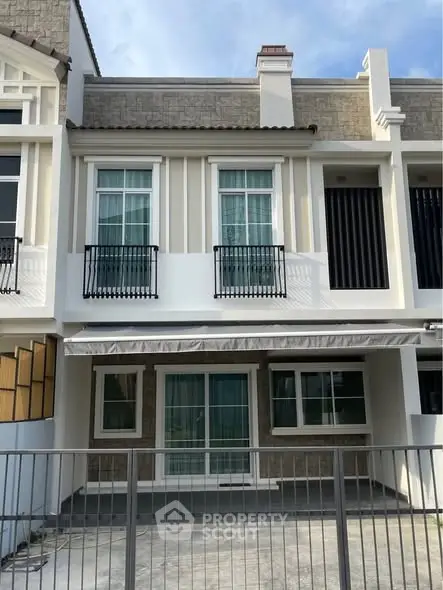 Charming two-story townhouse with modern facade and gated driveway, perfect for family living.