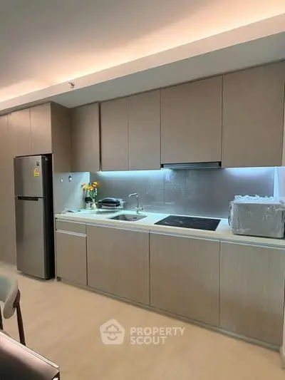 Modern kitchen with sleek cabinetry and built-in appliances in a contemporary apartment.