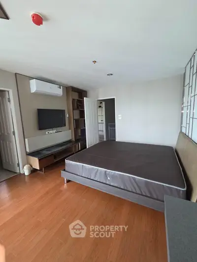 Spacious bedroom with modern design and wooden flooring in a stylish apartment.
