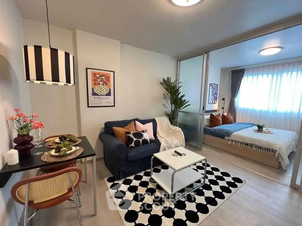 Stylish open-plan living room with cozy bedroom, modern decor, and natural light.