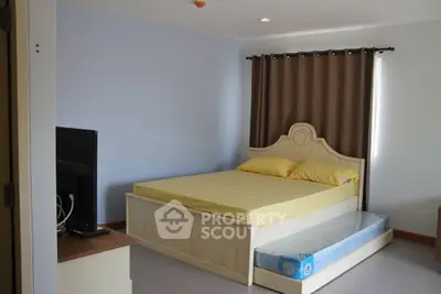 Cozy bedroom with stylish bed and TV, perfect for relaxation.