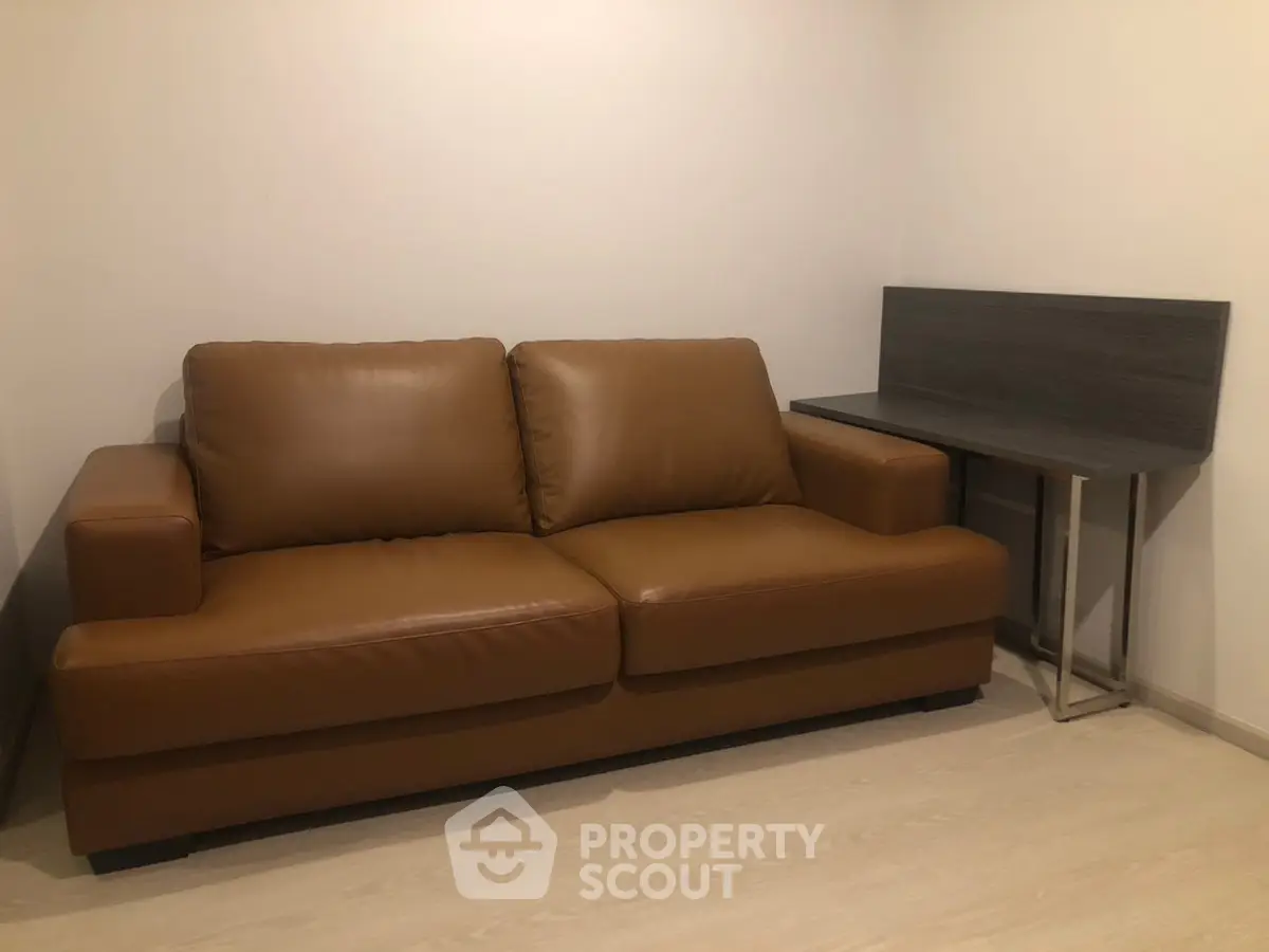 Cozy living room with brown leather sofa and modern side table