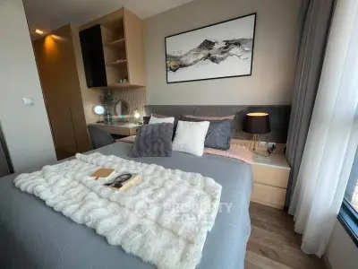 Cozy bedroom with modern decor and large window for natural light