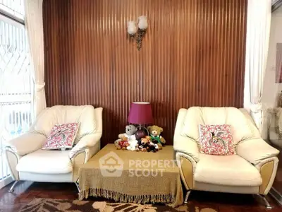 Cozy living room with plush armchairs and decorative pillows, perfect for relaxation.