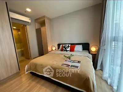 Modern bedroom with cozy decor and ensuite bathroom in stylish apartment.