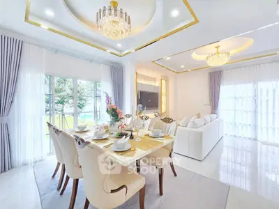 Luxurious open-plan living and dining area with elegant chandeliers and large windows.