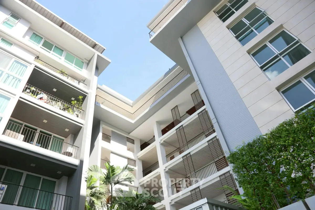 Modern apartment building with lush greenery and spacious balconies