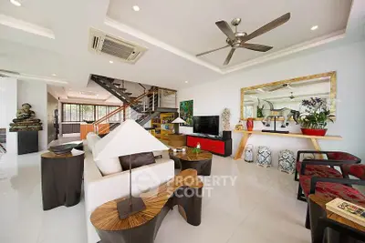 Spacious modern living room with stylish decor and open layout, featuring a ceiling fan and elegant furniture.