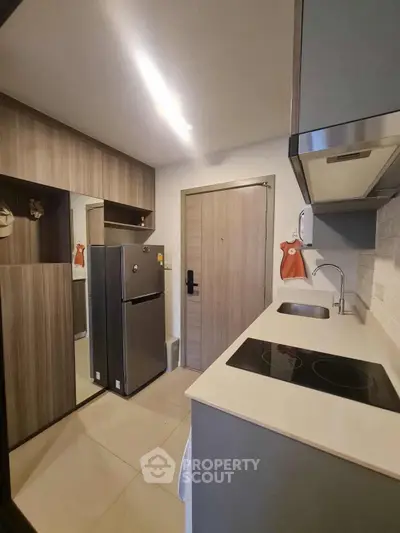 Modern compact kitchen with sleek cabinetry and electric cooktop