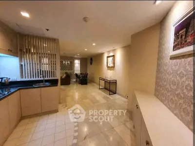 Spacious open-plan living area with modern kitchen and elegant decor, perfect for entertaining.