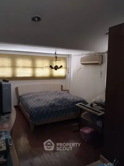 Cozy bedroom with wooden flooring and air conditioning, perfect for restful nights.