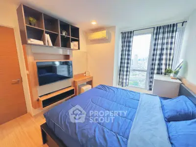 Modern bedroom with city view, featuring stylish shelving and cozy bedding.