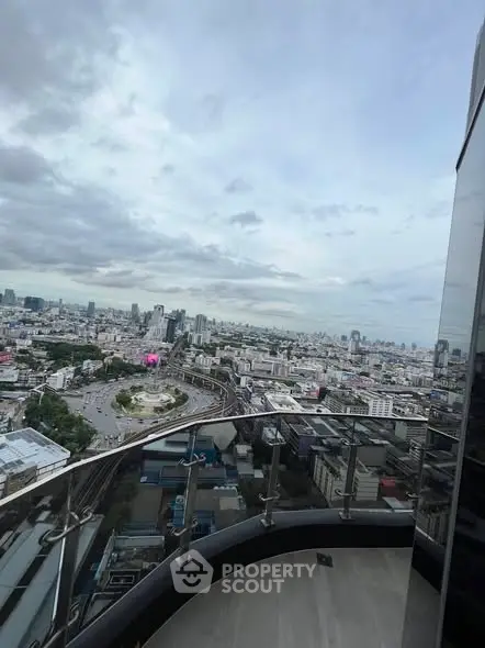 Stunning cityscape view from a high-rise balcony with glass railing.