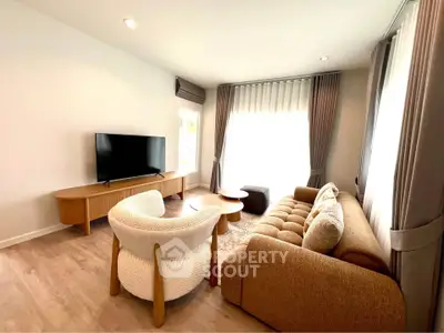 Spacious living room with modern furniture and natural light, perfect for relaxation and entertainment.