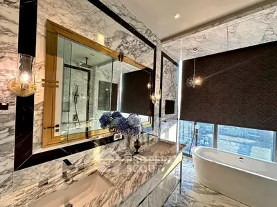 Luxurious marble bathroom with city view and elegant freestanding bathtub.