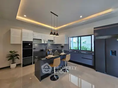Modern kitchen with sleek design, island seating, and stainless steel appliances
