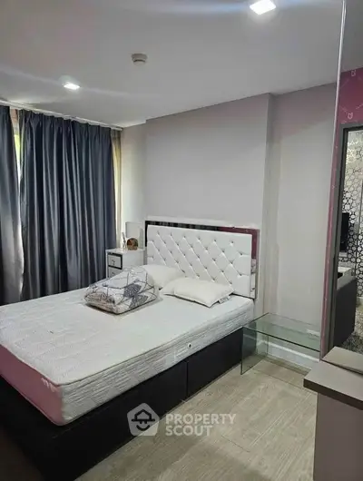 Modern bedroom with stylish decor and natural light, featuring a comfortable bed and sleek furnishings.