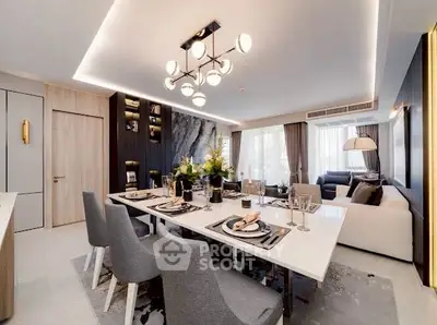 Luxurious open-plan living and dining area with elegant decor and modern lighting.