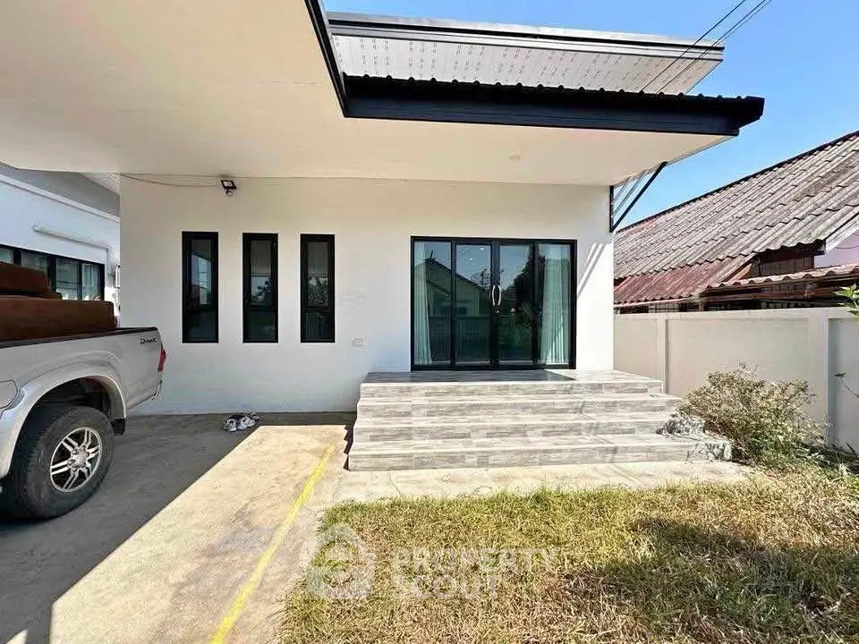 Modern single-story house with sleek design and spacious driveway