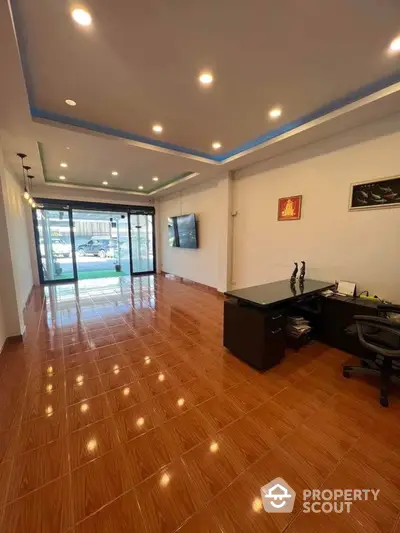 Spacious modern office space with tiled flooring and large windows for natural light.