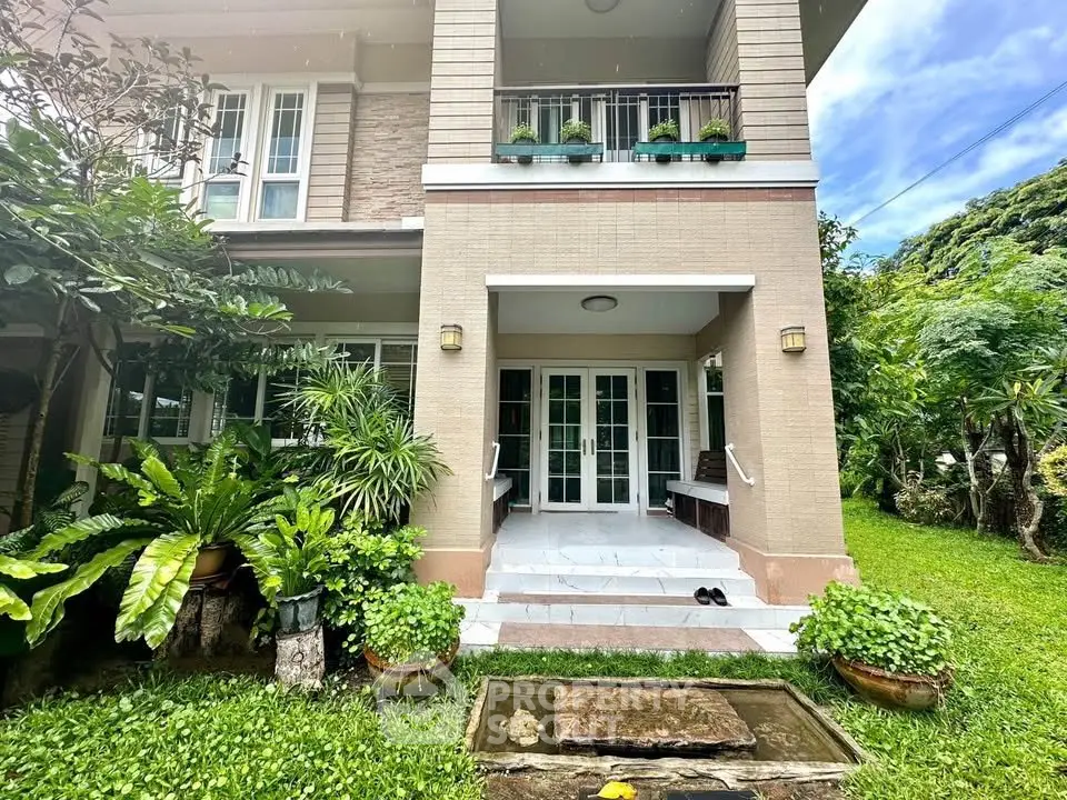 Charming two-story home with lush garden and inviting entrance, perfect for serene living.