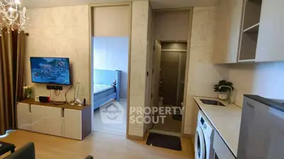 Modern apartment interior with open kitchen and cozy living area, featuring a washing machine and stylish decor.