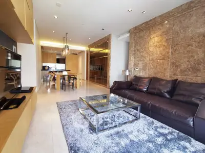Luxurious modern living room with elegant decor and open layout, featuring a plush sofa and stylish dining area.